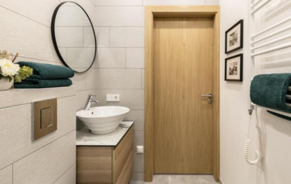 un baño con lavabo y espejo en Defaris Apartments, en Dargai