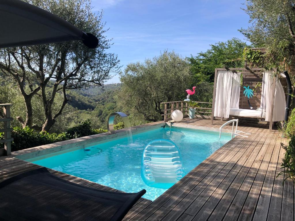 - une piscine avec une terrasse et une chaise à côté dans l'établissement Cottage Provençal 3 Chambres piscine et spa privés Côte d'Azur très calme campagne proche Nice Monaco et Cannes, à Colomars