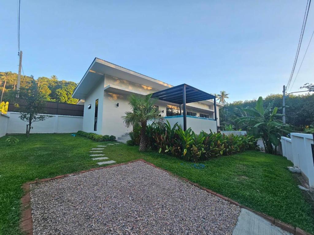 a small white house with a grass yard at Pontakorn Villa 1 in Ko Phangan