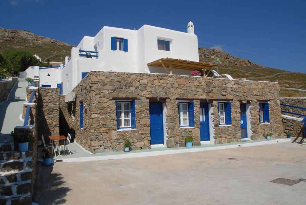 un edificio con puertas azules en una colina en Adonis Rooms, en Playa Kalo Livadi