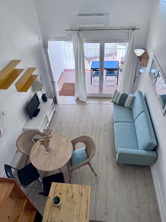 a living room with a blue couch and a table at Apartaments Aeroclub in Empuriabrava