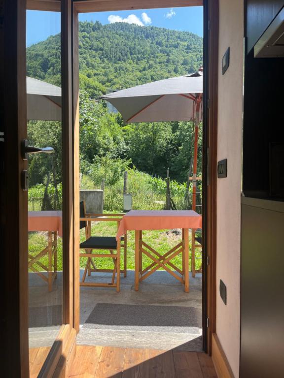 a patio with a table and an umbrella at Chalet Monaci alla Fontana "Junior suite" in Albosaggia