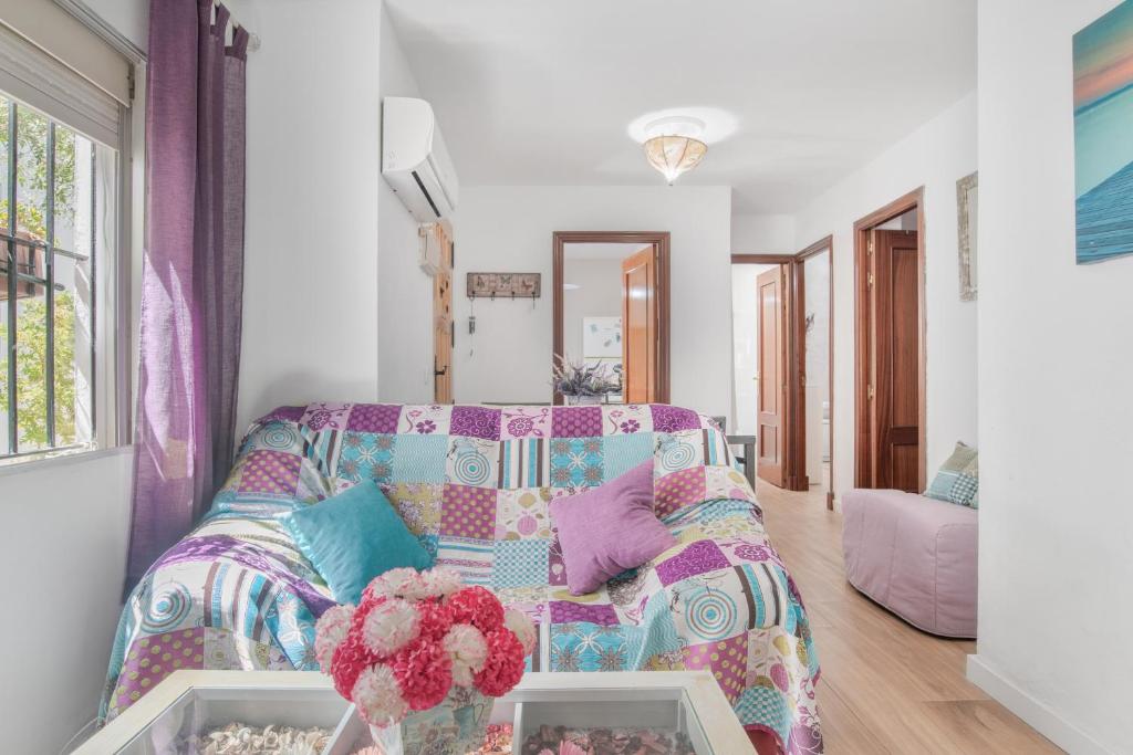 ein Wohnzimmer mit einer Couch mit einer bunten Decke in der Unterkunft Espelete in El Puerto de Santa María