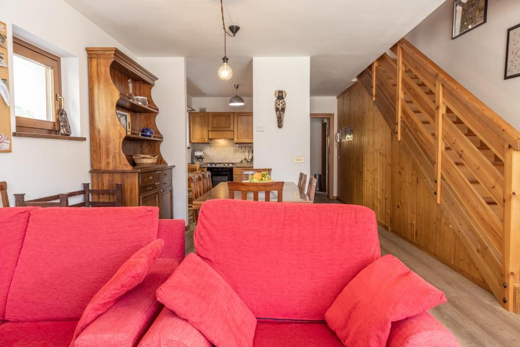 a living room with a red couch and a kitchen at Casa Cavina, ampia con giardino e garage in Venas