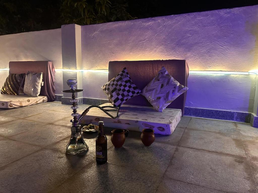 a purple couch with pillows and bottles on the ground at THS Home Stay in Varanasi