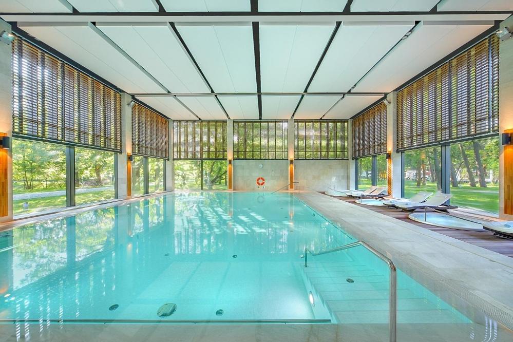 a large swimming pool with a large ceiling at Eva Park Life & Spa in Konstancin-Jeziorna