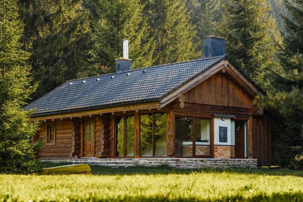 a log cabin in a field with trees at Šumavská Vlčice - Rybářský srub in Strážný