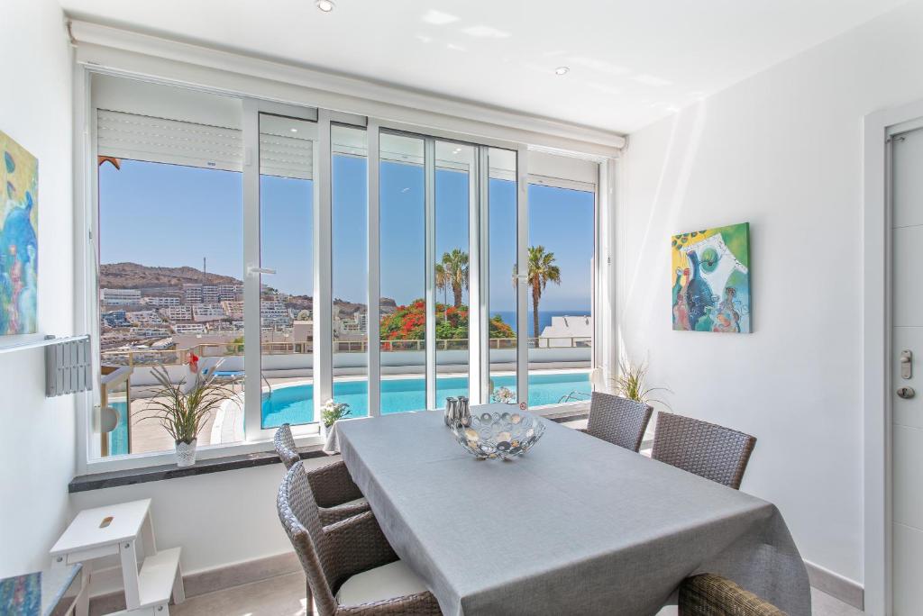 een eetkamer met een tafel en uitzicht op de oceaan bij Brisas Canarias in Puerto Rico de Gran Canaria