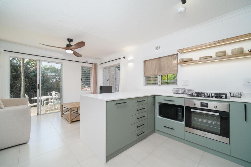 a kitchen with white walls and a ceiling fan at Ocean Breeze Escape in Ballito