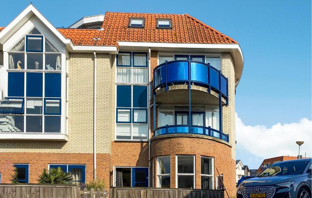 ein Haus mit einem blauen Balkon an der Seite in der Unterkunft Nice Apartment In Bergen Aan Zee in Bergen aan Zee