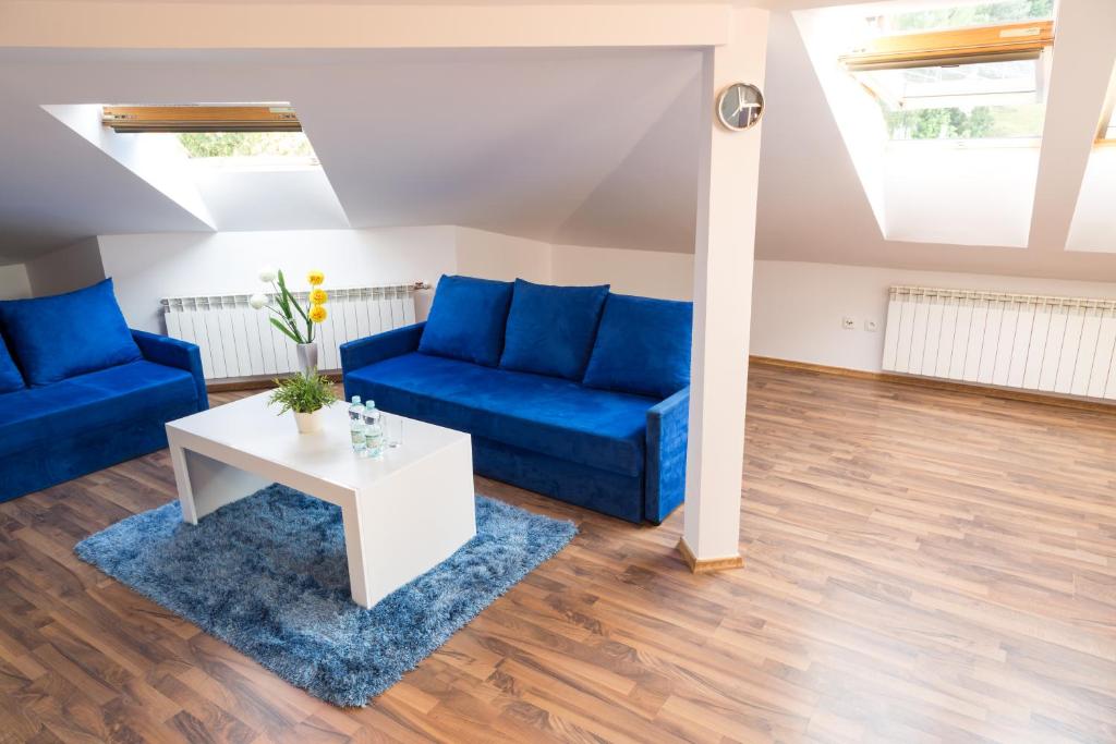 uma sala de estar com sofás azuis e uma mesa em Apartament City Center Studio DeLuxe em Krynica-Zdrój