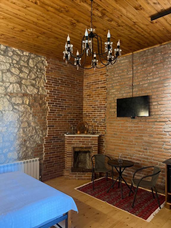 a brick room with a table and a fireplace at Old Balcony in Kutaisi