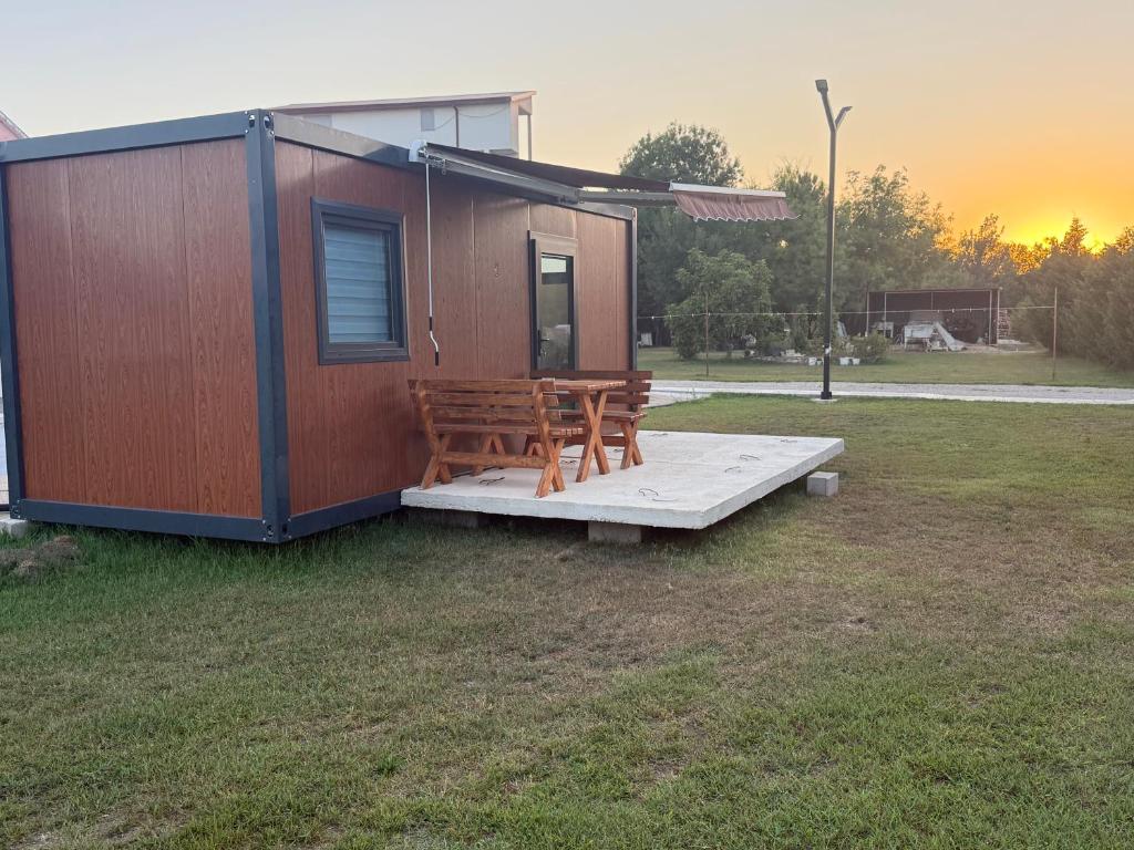a tiny house with a bench on a field at Mobilna kucica M in Donji Štoj
