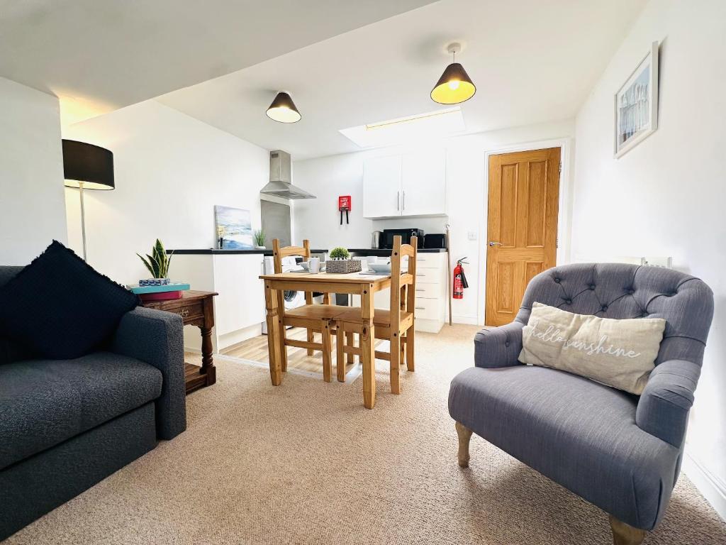 een woonkamer met een tafel en stoelen en een keuken bij The Cobbles in Filey