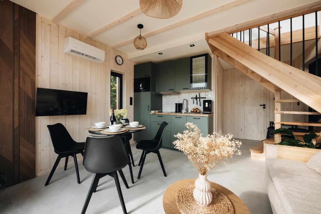 a living room and kitchen with a table and chairs at Wyspa Roztocze in Kulików
