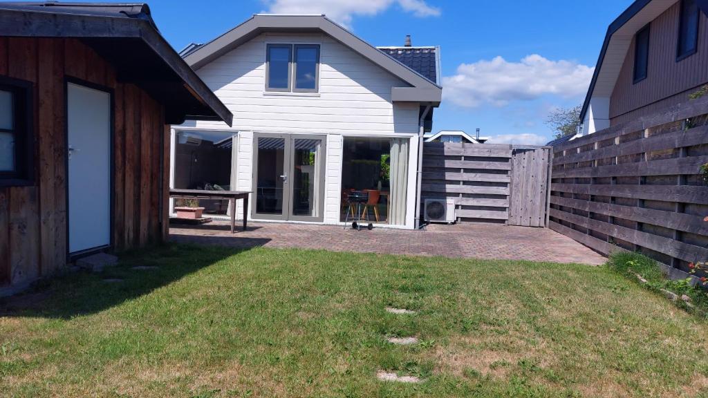 a white house with a gate and a fence at Vakantiewoning Loosdrechtse Plassen in Loosdrecht