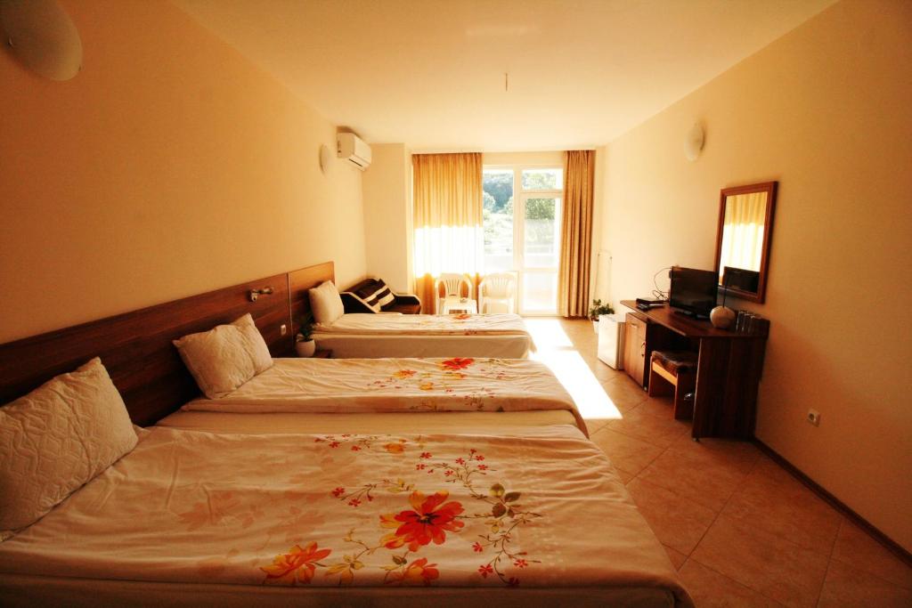 a hotel room with two beds with flowers on them at Hotel Marant in Sozopol