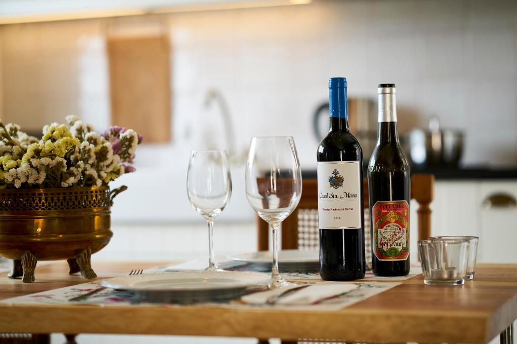 two bottles of wine and two glasses on a table at Sparrow Sintra Nest in Sintra