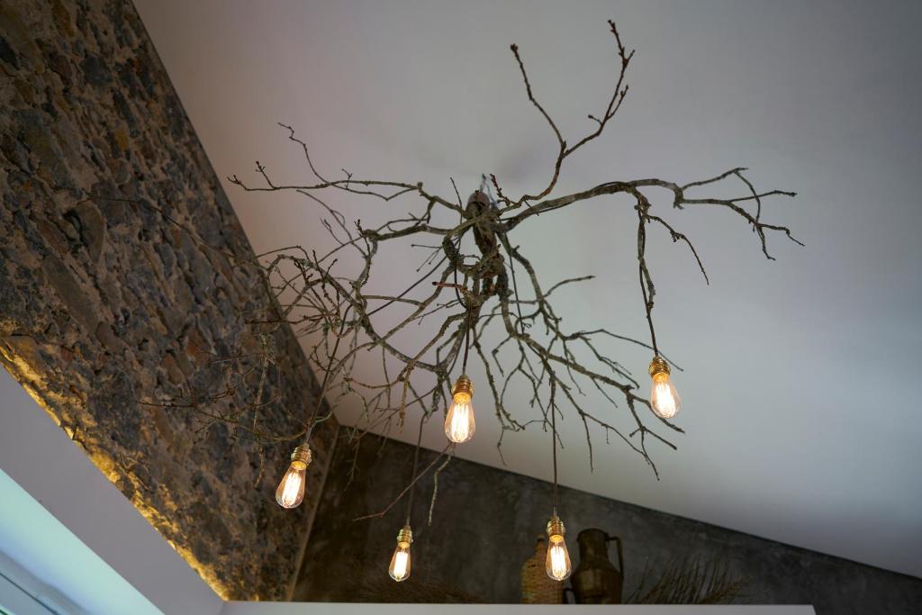 a branch chandelier with lights hanging from a ceiling at Sparrow Sintra Nest in Sintra