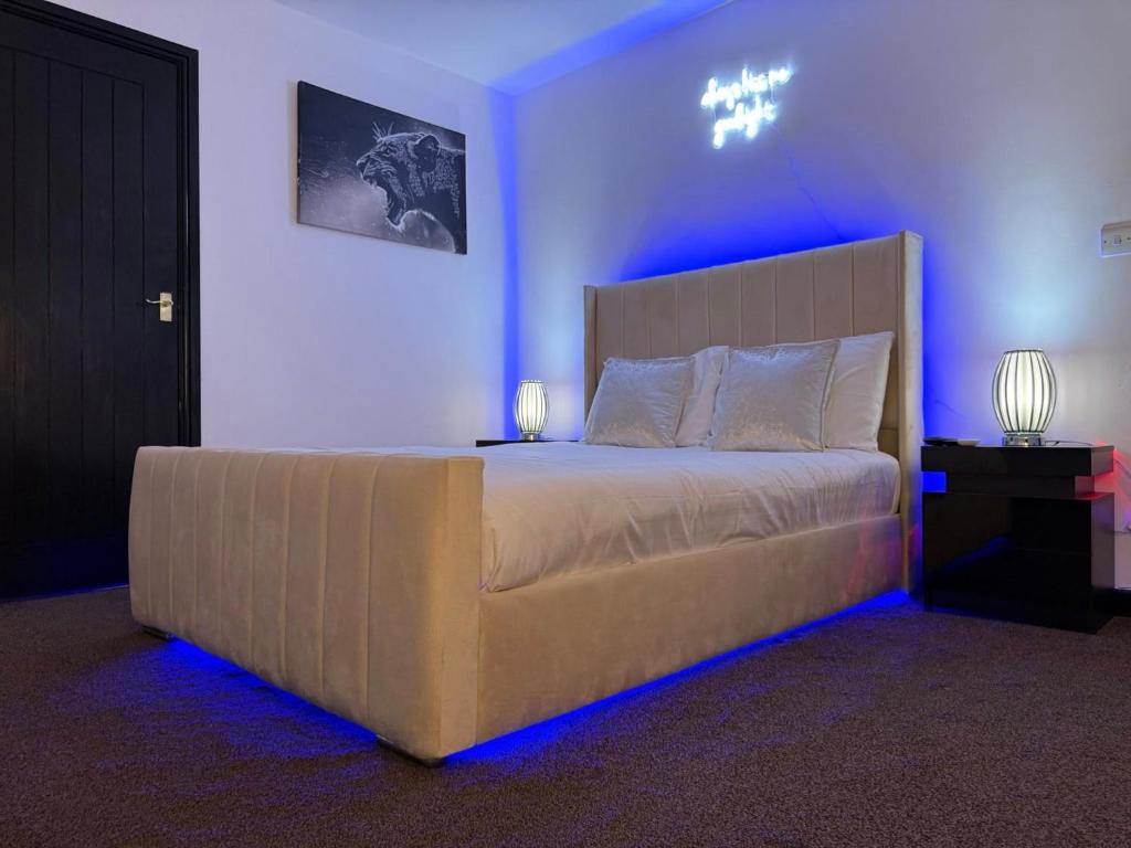 a bedroom with a large bed with blue lights at Mansa Halifax in Halifax