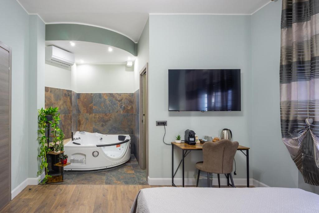 a bedroom with a tub and a bed and a table at Aurelia Garden Suite in Rome