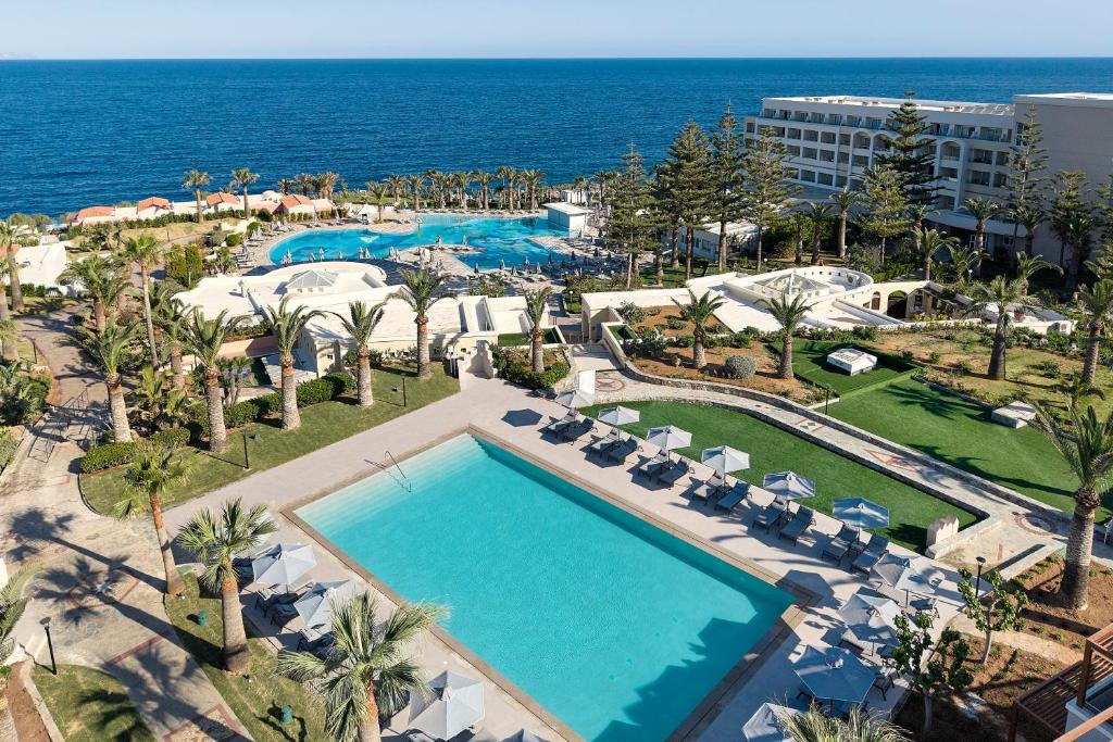an aerial view of a resort with a pool and the ocean at Iberostar Waves Creta Panorama & Mare in Panormos Rethymno