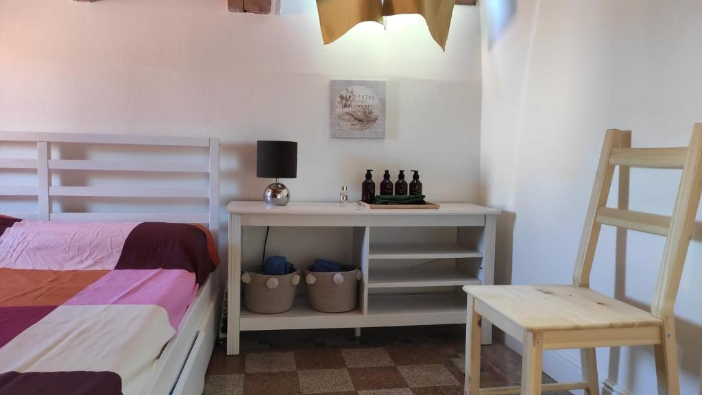 a bedroom with a bed and a table with bottles of wine at Arco & Íris in Livorno