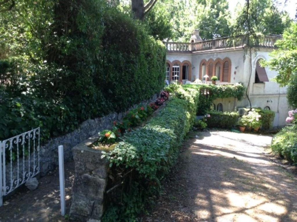 an old house with a fence and a garden at Villino a Fiuggi in Fiuggi