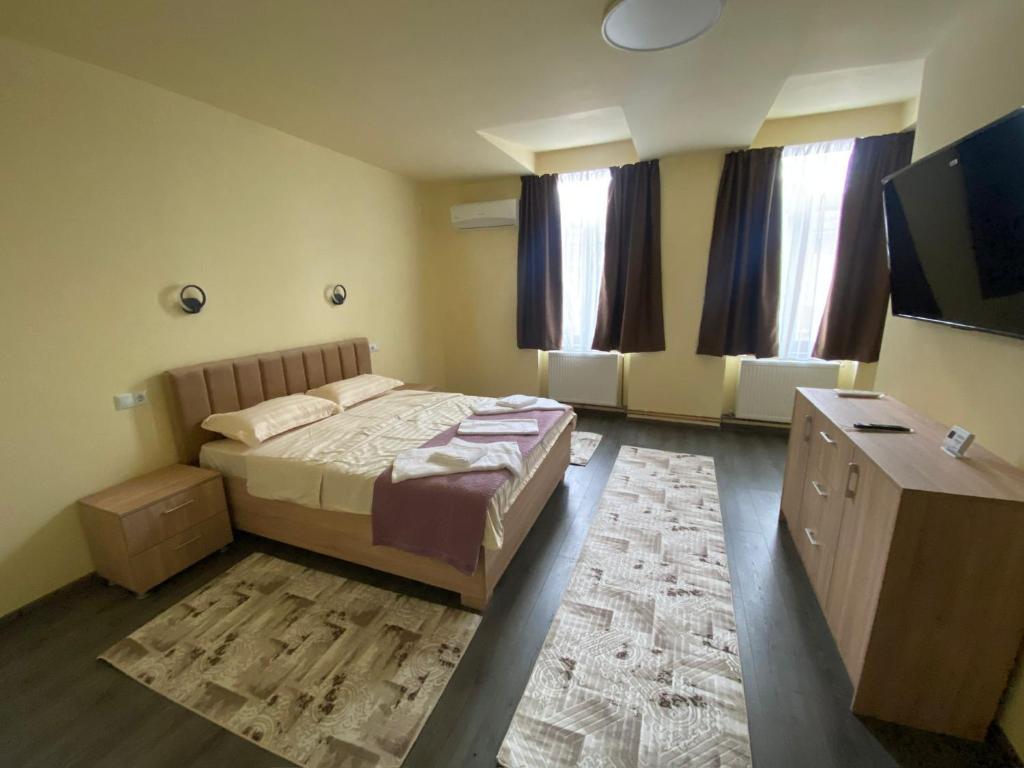 a bedroom with a bed and a flat screen tv at Apartamentele Liliacul in Sighetu Marmaţiei