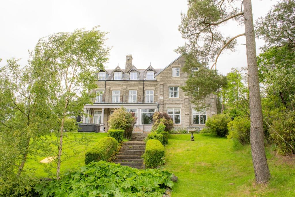 una vista exterior de una gran casa con árboles en Finest Retreats - Evergreen Manor, en Middleton in Teesdale