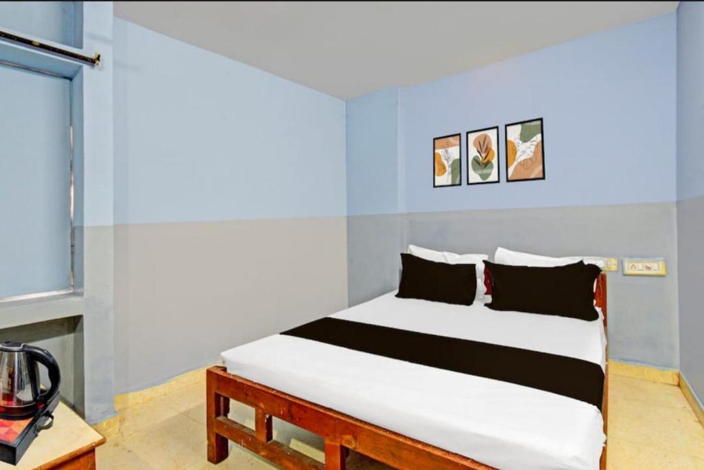 1 dormitorio con cama blanca y almohadas blancas y negras en MOONLIGHT Inn, en Hyderabad