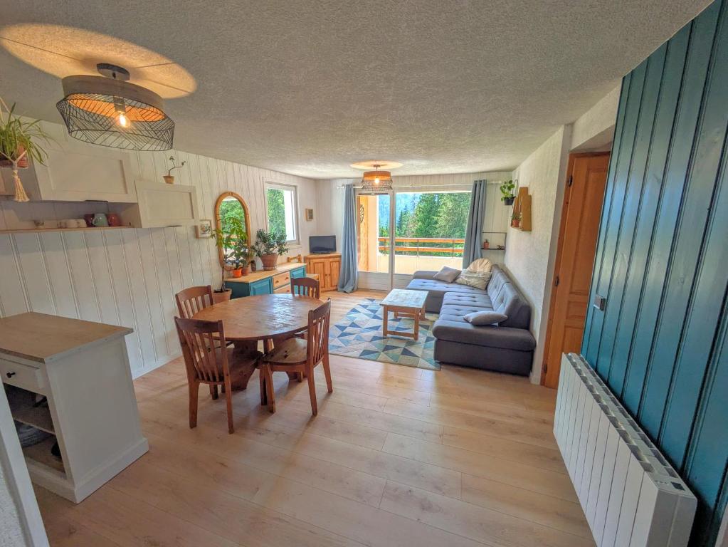un salon avec une table et un canapé dans l'établissement Grand Appartement, 2 Chambres, à Arâches-la-Frasse