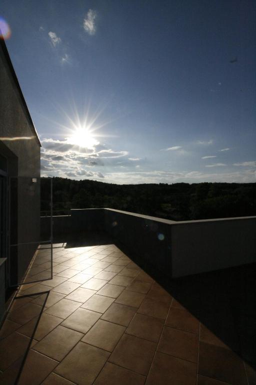 a balcony of a building with the sun in the sky at Hotel Marant in Sozopol