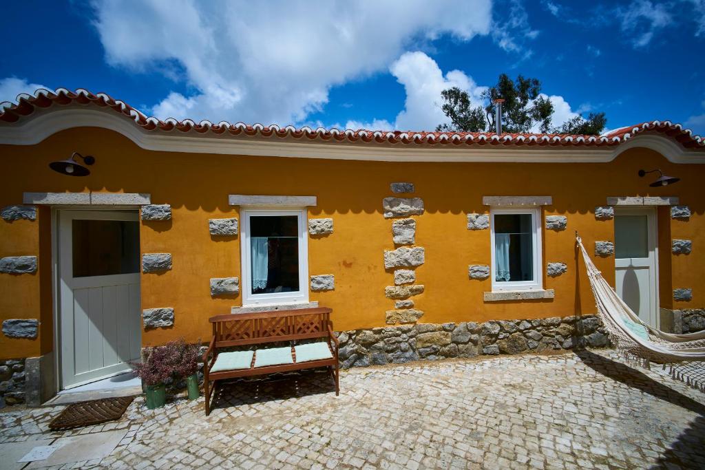 a yellow house with a bench in front of it at Sparrow Sintra Nest in Sintra