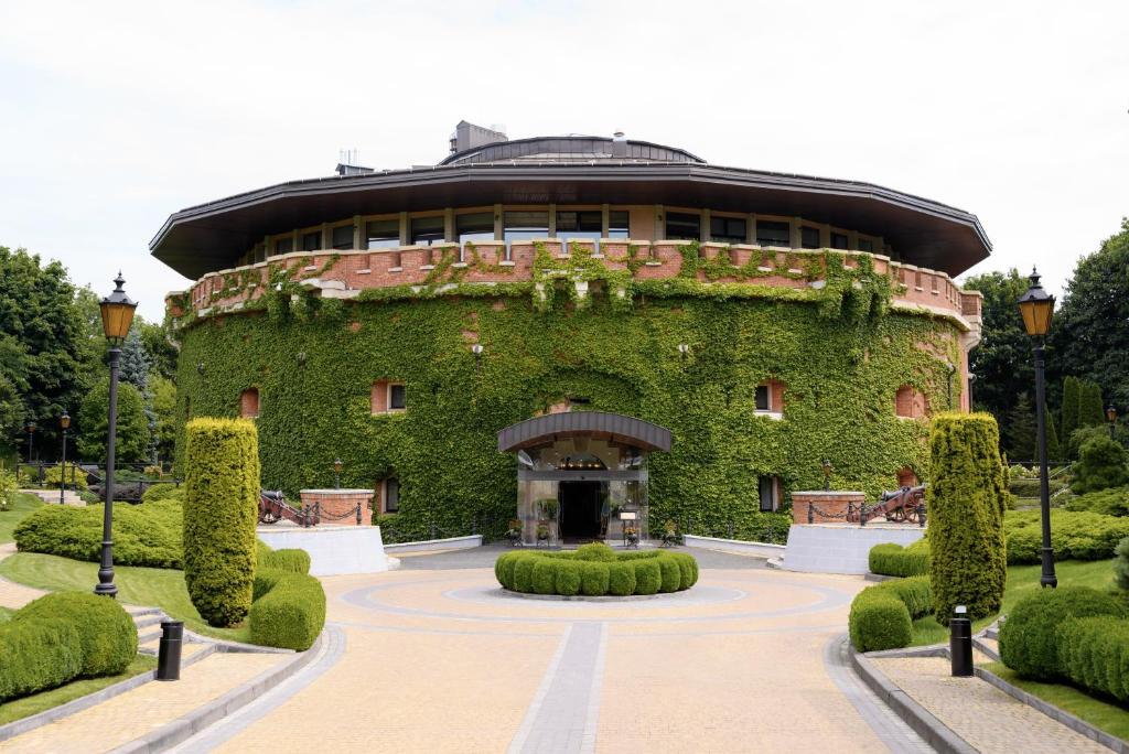 a building covered in green ivy with a courtyard at Citadel Inn Gastro Boutique Hotel - Готель Цитадель Львів in Lviv