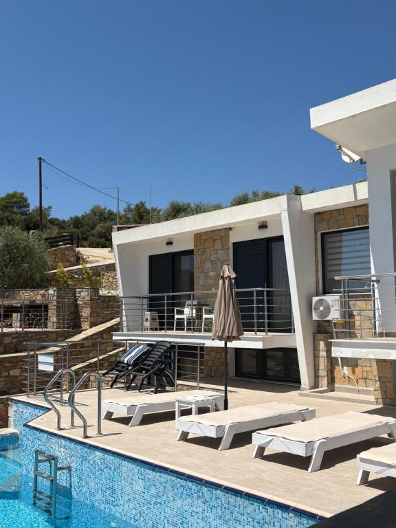 a villa with a swimming pool and a house at Villa Sangria in Skala Marion