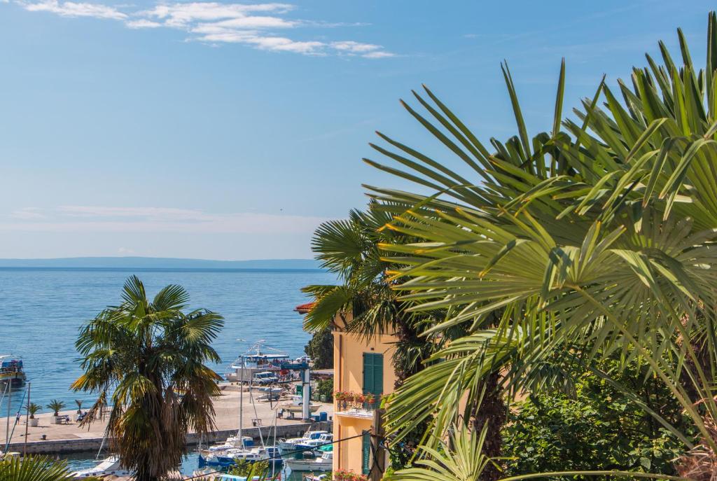 widok na plażę z palmami i ocean w obiekcie Sunny Apartment Anamaria Opatija w mieście Opatija