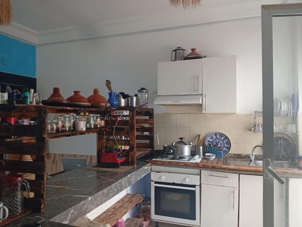 a kitchen with white cabinets and a stove top oven at Nouvelle ville Ibn Battouta in Tangier