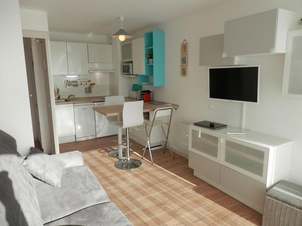 un salon avec une table et une cuisine dans l'établissement T2 avec piscine, terrasse et parking à Vieux-Boucau - FR-1-379-81, à Vieux-Boucau-les-Bains