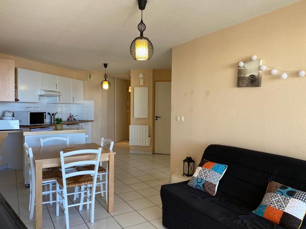 un salon avec un canapé et une table et une cuisine dans l'établissement Appartement T2 avec terrasse, parking, animaux admis - FR-1-379-172, à Vieux-Boucau-les-Bains