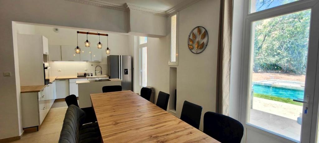 a kitchen and dining room with a wooden table and chairs at Superb house with pool in Saint-Raphaël in Saint-Raphaël