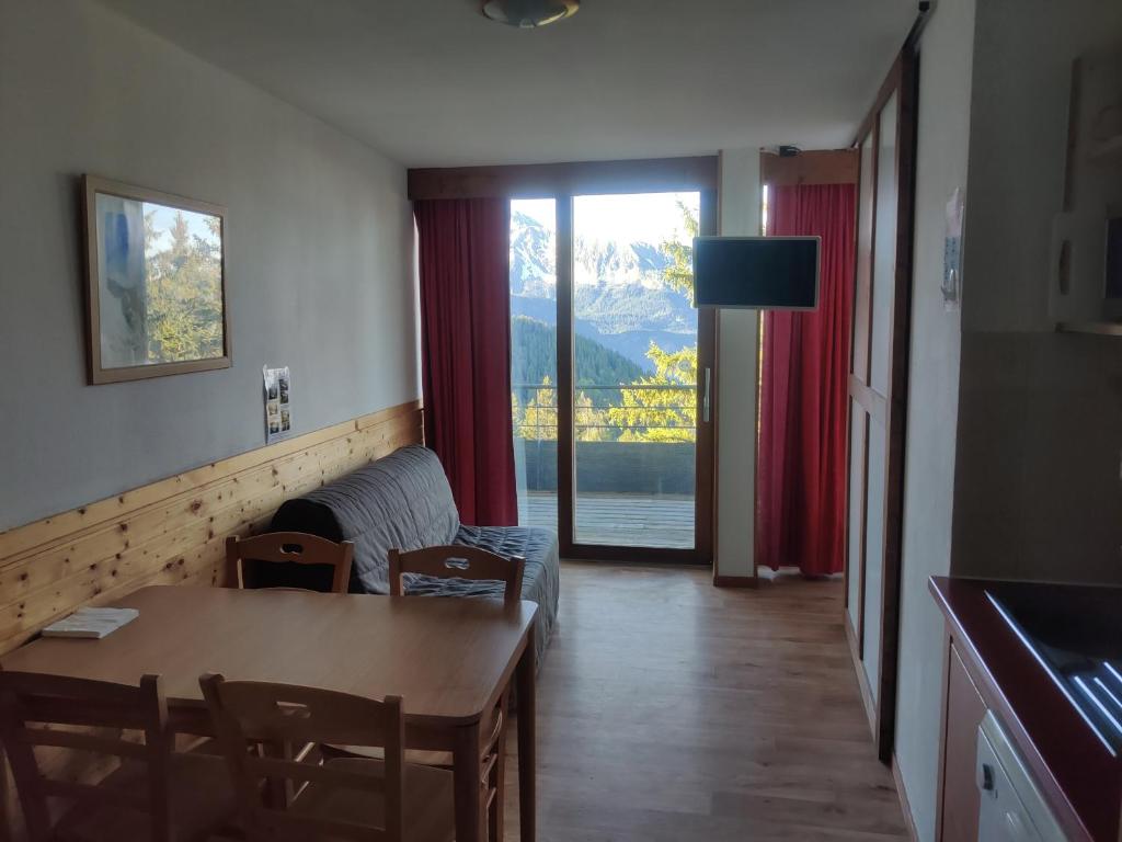 sala de estar con mesa y vistas a la montaña en V du Bachat Epicea A N24 2P6, en Chamrousse