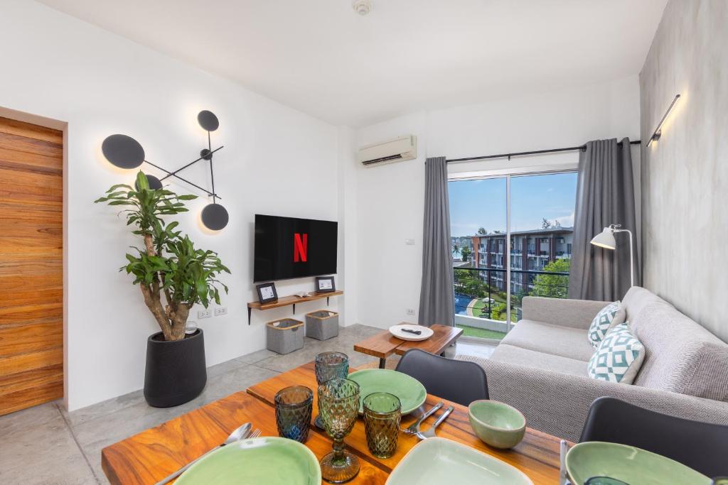 Nathon BayにあるNEW 2 bedrooms condo on Bangrak beachのソファとテーブルのあるリビングルーム