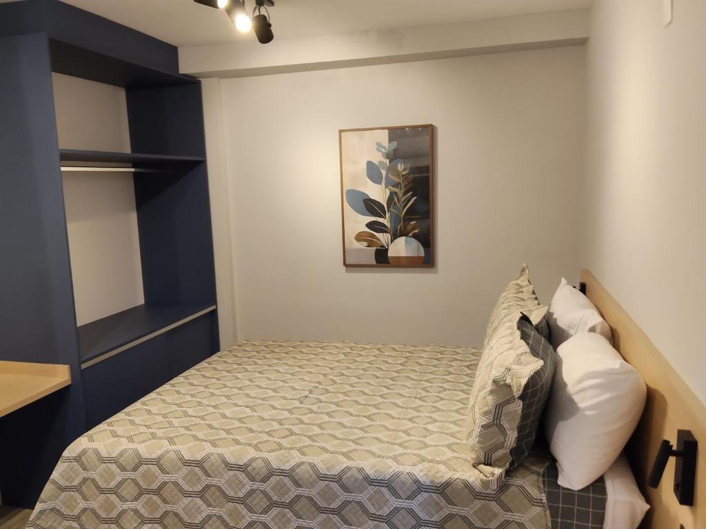 a bedroom with a bed and a picture on the wall at Novo studio sofisticado ao lado do Allianz Parque in Sao Paulo