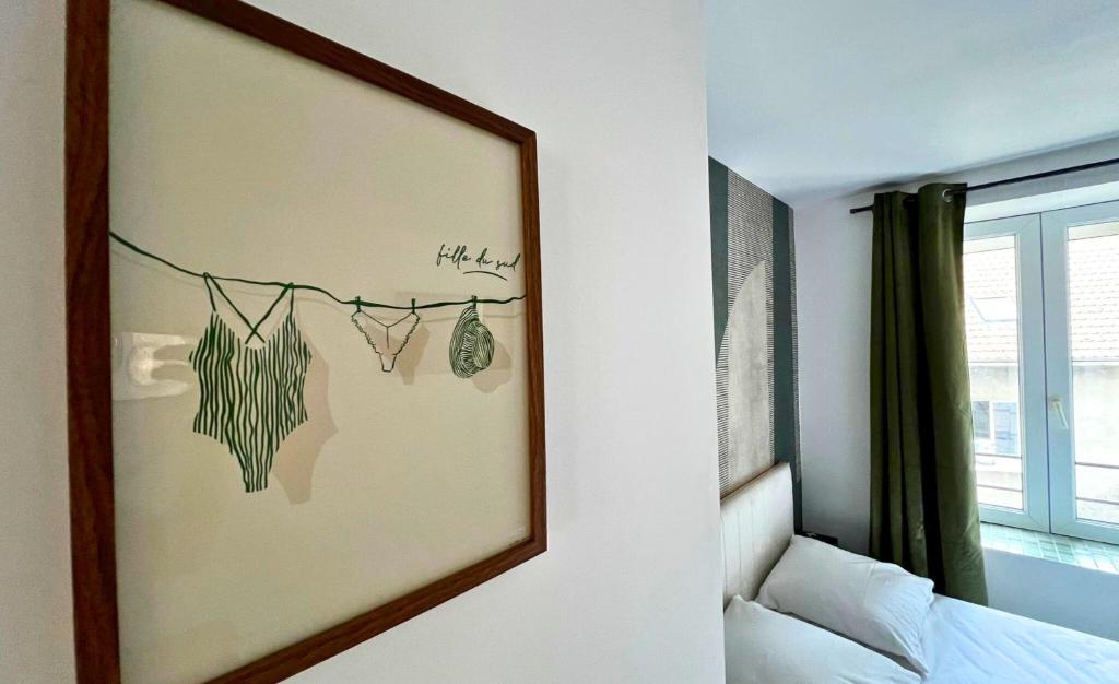 a mirror hanging on a wall in a bedroom at Le Chti nid d'Opale in Boulogne-sur-Mer