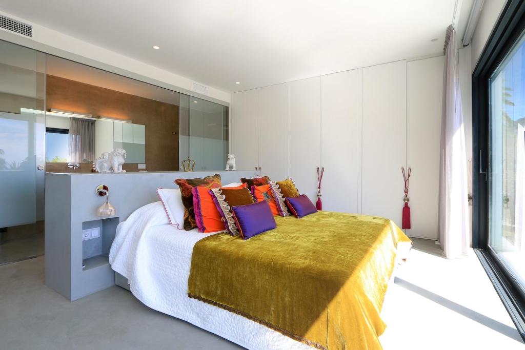 ein Schlafzimmer mit einem großen Bett mit bunten Kissen in der Unterkunft The Perfect Luxury Sea Views, Ibiza Villa 1011 in Talamanca