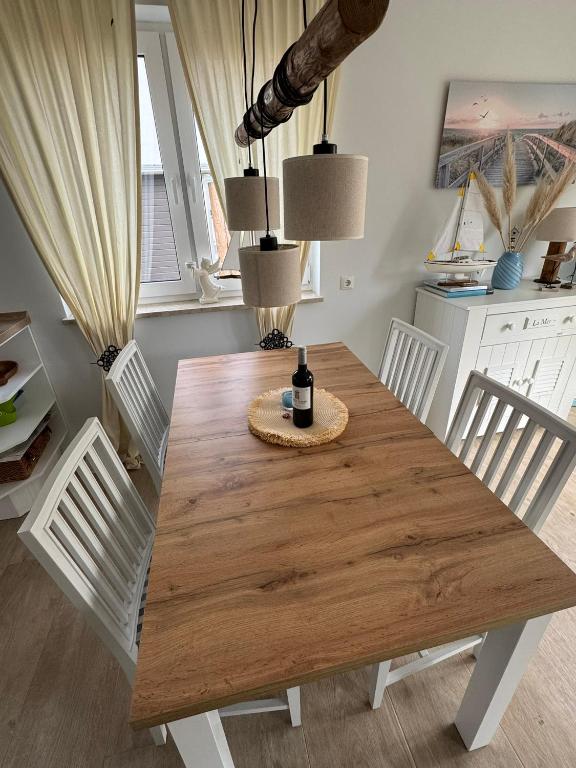 a dining room table with a bottle of wine on it at Haus Luca Fuhlendorf in Fuhlendorf