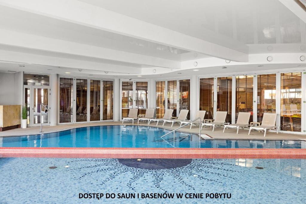 una piscina con sedie in un edificio di Maloves Resort & Spa, pokoje w bocznych budynkach a Władysławowo