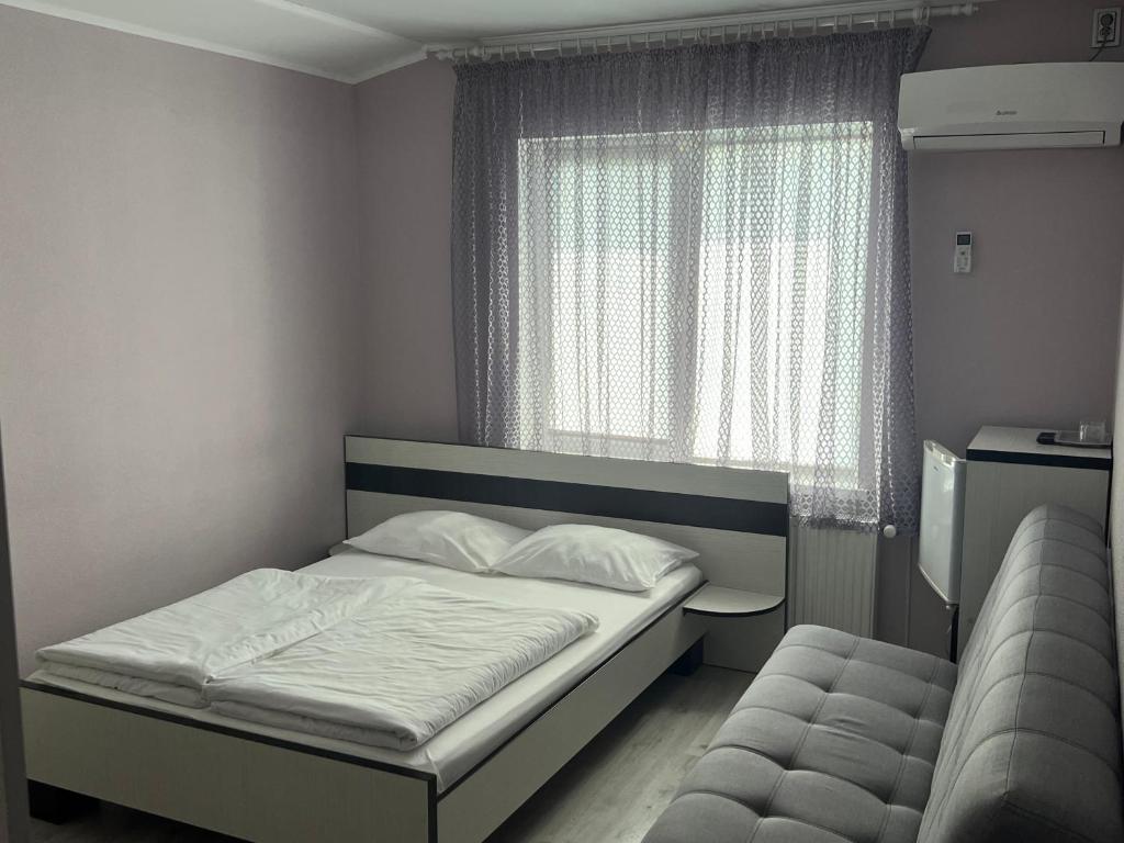 a small bedroom with a bed and a window at Guest House MAX in Khmelnytskyi