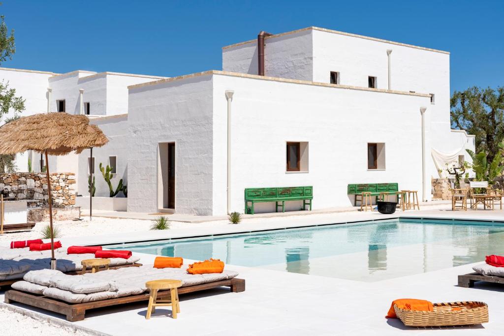 a villa with a swimming pool and a resort at Masseria Guadalupe, The Mascienda in Ostuni